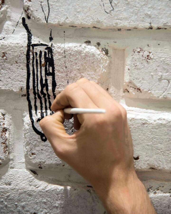 Close view of traditional sign painting techniques used for wall graphics in the Kiehl’s London flagship store