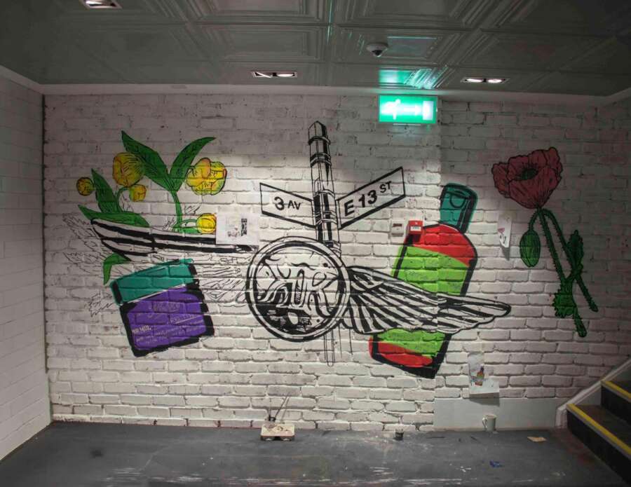 Large hand painted wall graphic featuring illustrated product and botanical elements in Kiehl’s London store