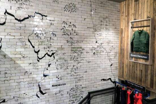 Hand painted wall map across reclaimed tiles inside the Patagonia Manchester store stairwell