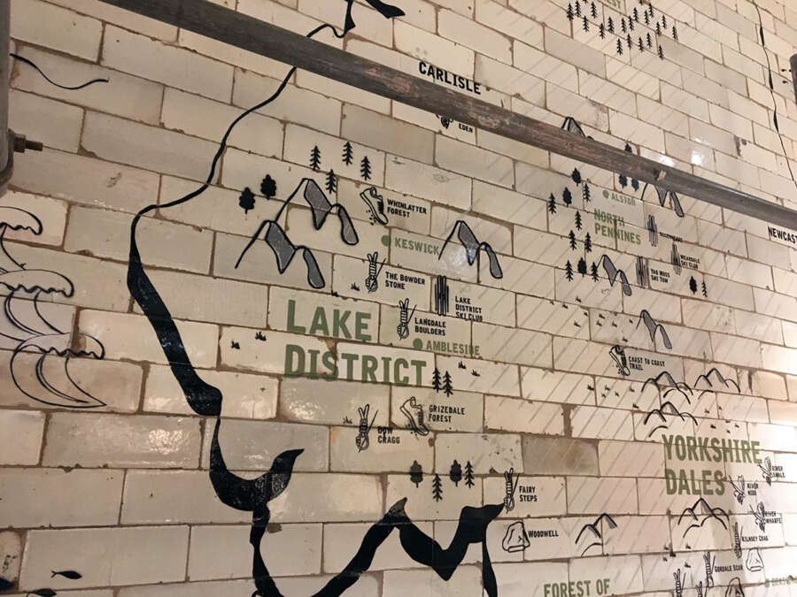 Lake District section of painted wall map graphic applied to reclaimed tiles in Patagonia Manchester