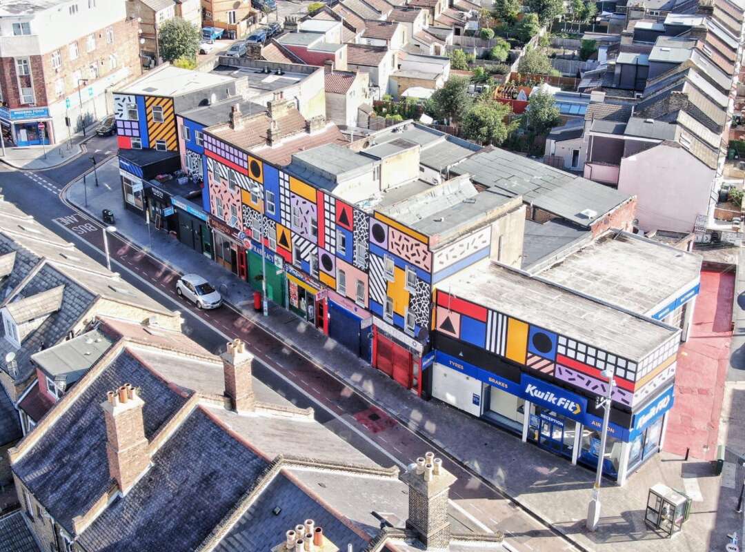 Aerial view of Walala Parade mural by Camille Walala covering a full parade of buildings on Leyton High Road London