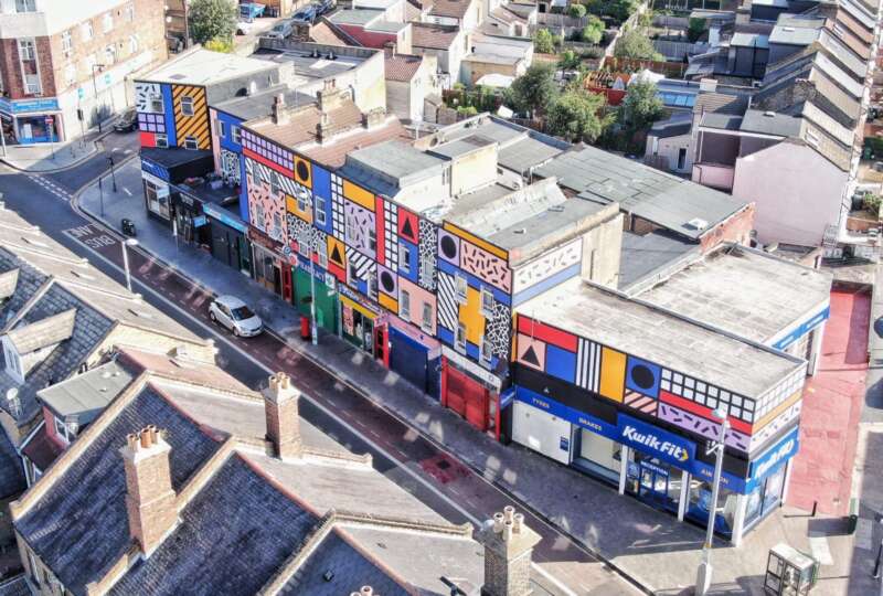 Aerial view of Walala Parade mural by Camille Walala covering a full parade of buildings on Leyton High Road London