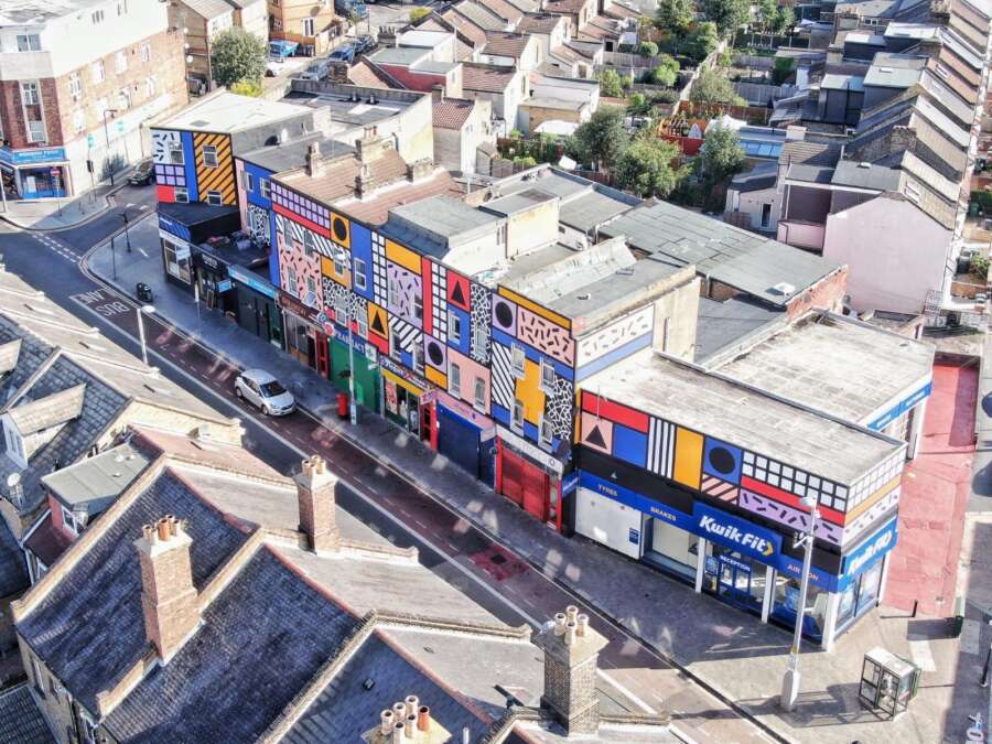 Aerial view of Walala Parade mural by Camille Walala covering a full parade of buildings on Leyton High Road London