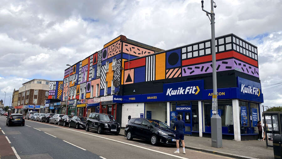 Street perspective of Camille Walala mural along Leyton High Road London showing geometric building artwork