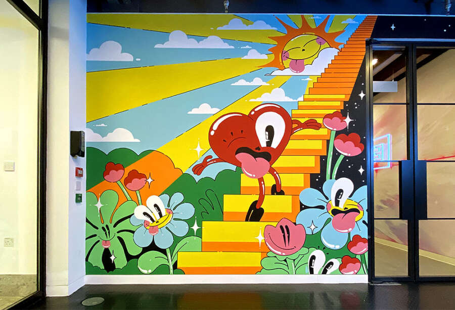 Large colourful mural by Hattie Stewart featuring illustrated staircase and characters at EMI London office