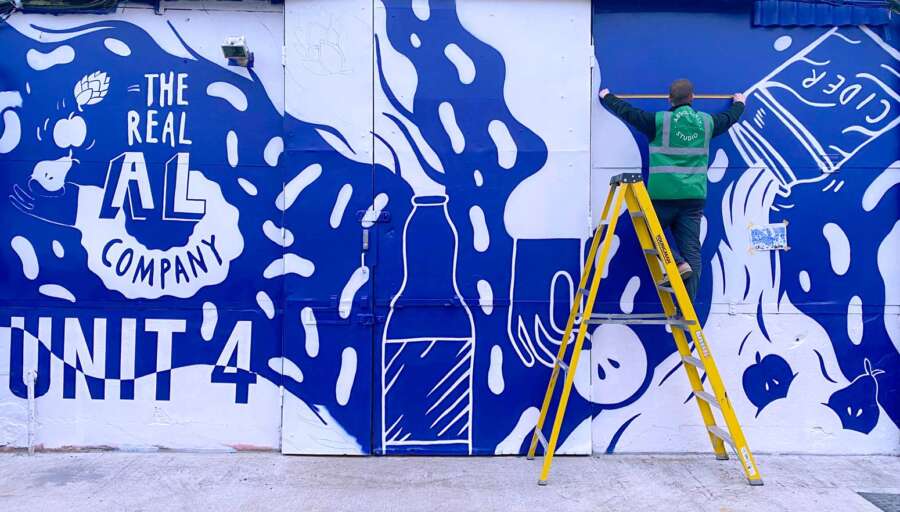 Large-scale mural installation by Becky Liddiard being painted on exterior wall in Walthamstow