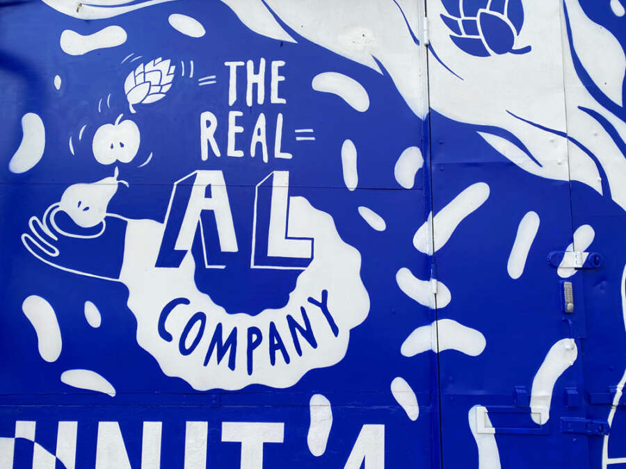 Blue monochrome mural detail showing The Real Al Company lettering by Becky Liddiard
