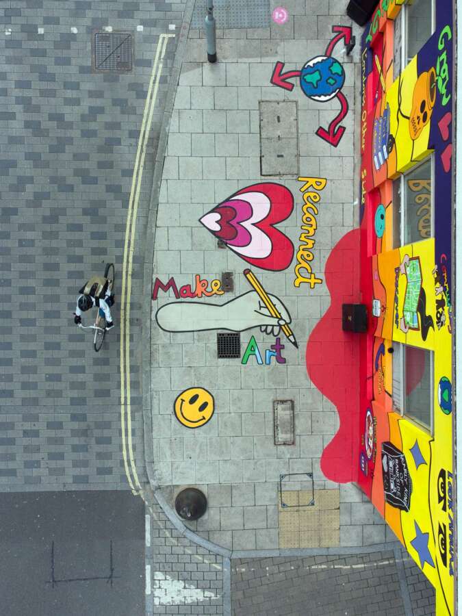 Aerial view of Hannah Hill public artwork extending from building wall onto pavement in Bankside