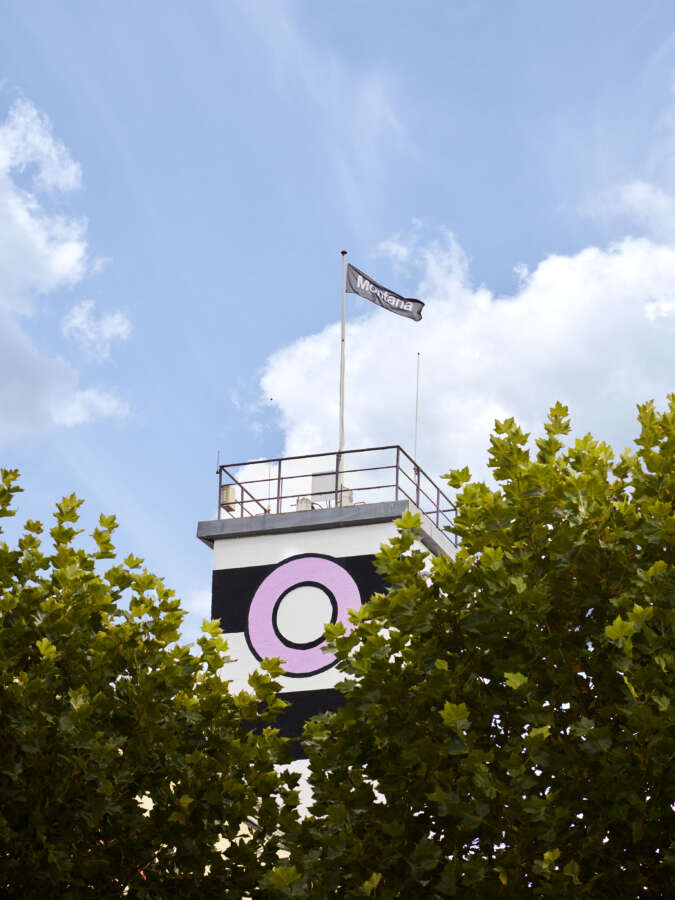 Camille Walala factory mural tower framed by trees at Montana Furniture site in Denmark