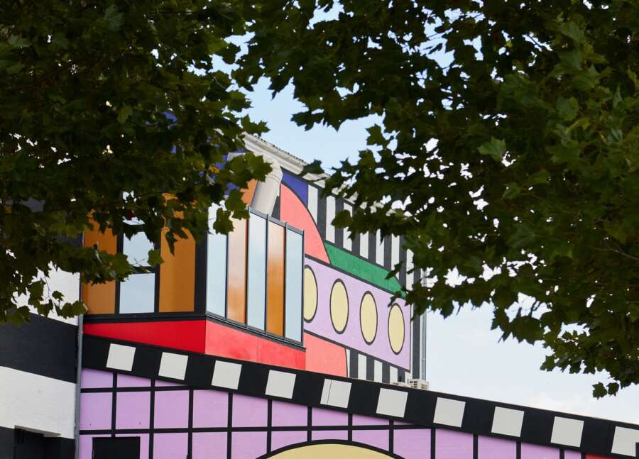 Side elevation of Montana Furniture factory featuring Camille Walala building wrap artwork