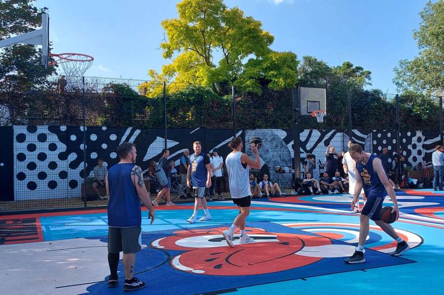 Players using the painted basketball court mural at Orchard Park Portsmouth community court