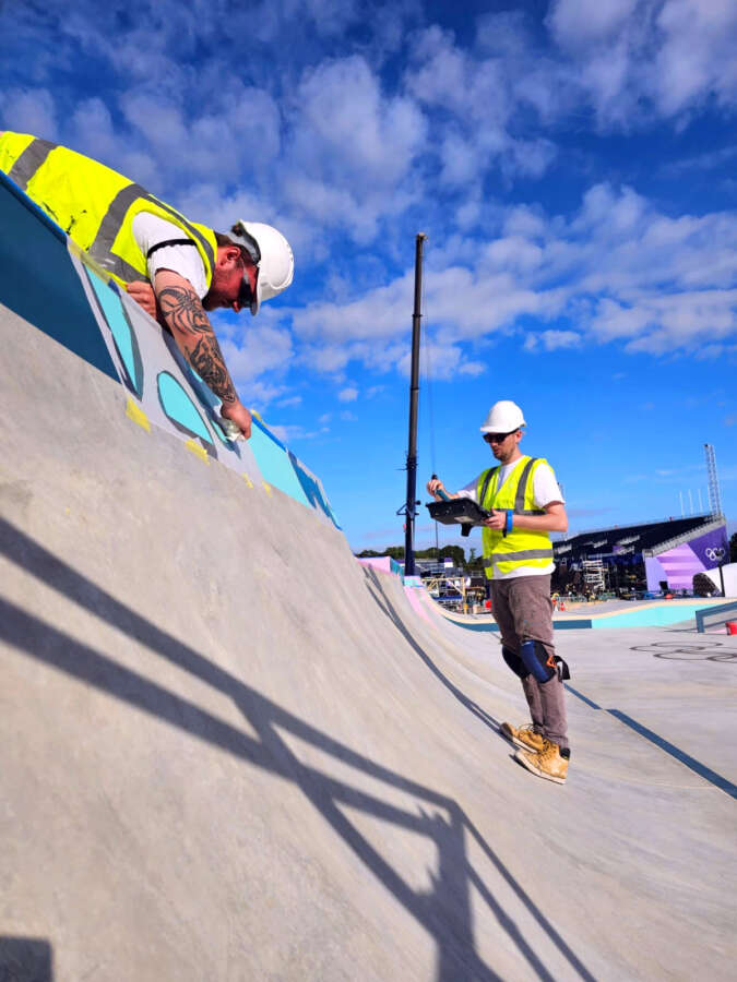 Installation team painting skatepark graphics for the Paris 2024 Olympic skateboarding venue