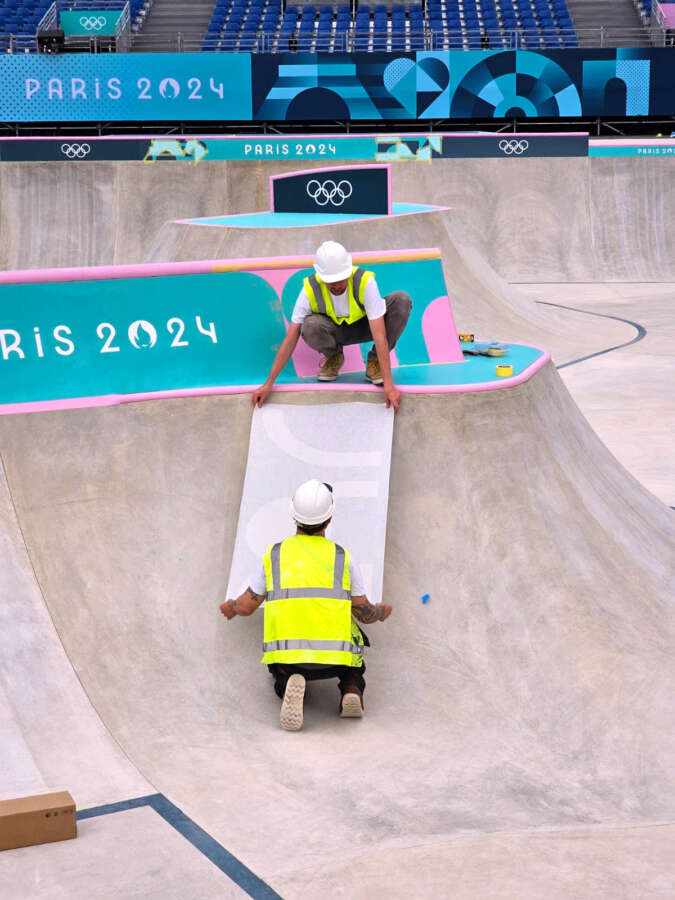 Crew preparing painted skatepark surface for the Paris 2024 Olympic skateboarding venue