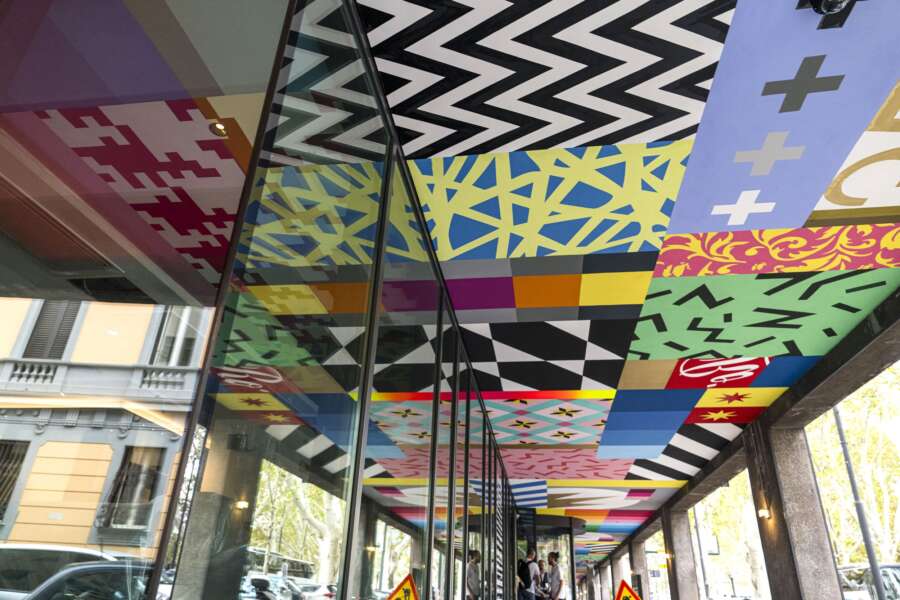 Reflection of vibrant ceiling mural artwork in glass panels at CitizenM Hotel Rome