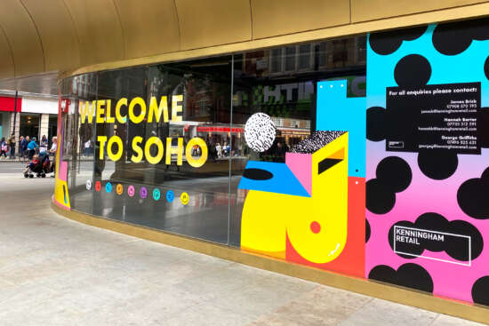 Colourful vinyl mural by Darren John featuring Welcome to Soho message on development hoarding in central London