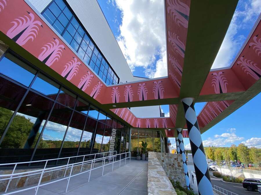Perspective view of large geometric canopy mural painted across exterior beams in Boston
