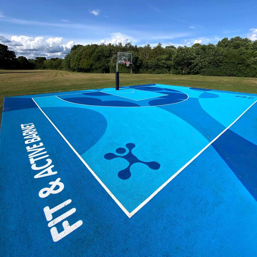 Painted basketball court mural in Barnet featuring abstract blue graphics by Darren John