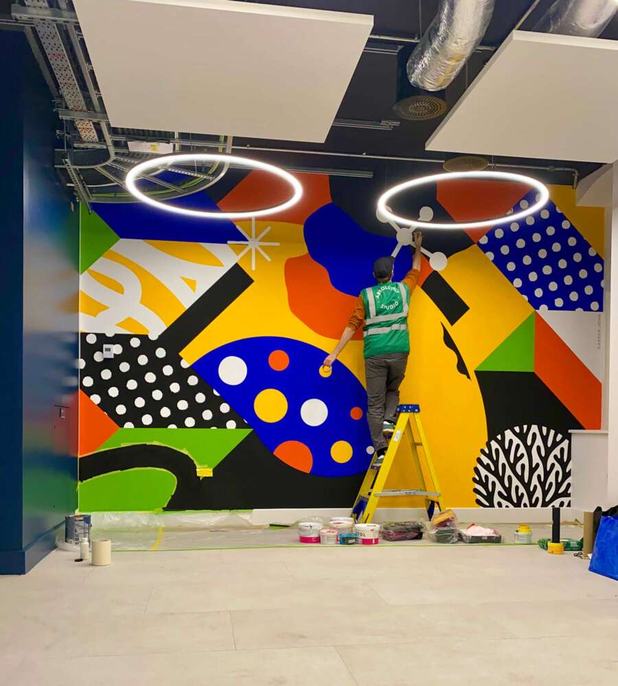 Darren John painting a large abstract mural at the London School of Hygiene & Tropical Medicine