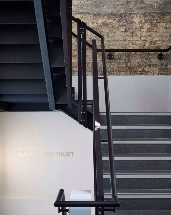 Hand painted donor wall text beside stairwell architecture inside Brighton Dome