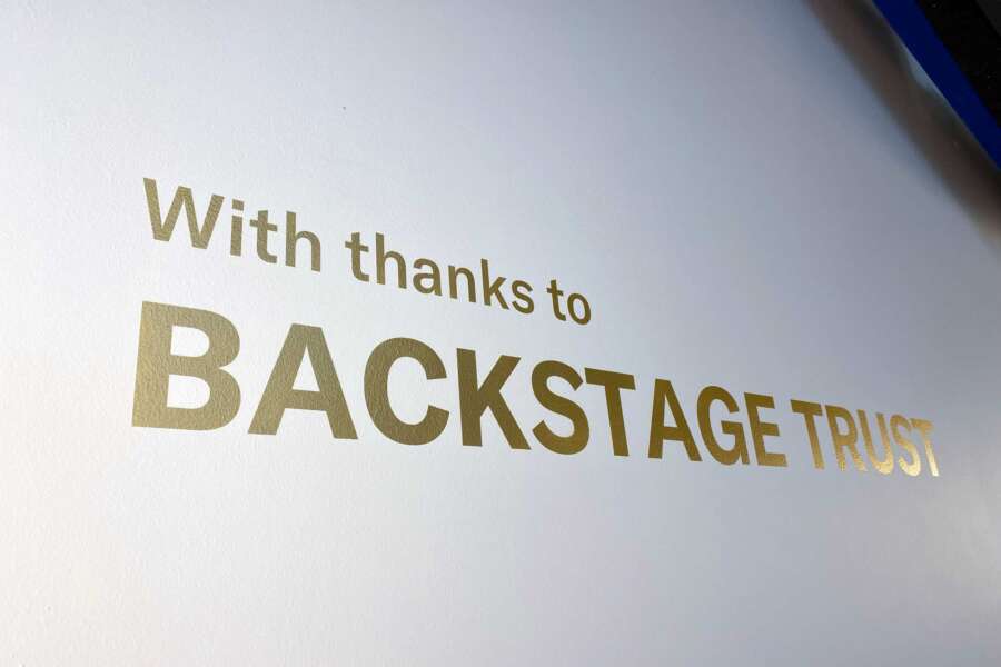 Hand painted gold donor lettering reading Backstage Trust inside Brighton Dome