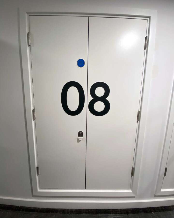 Painted cupboard door numbering 08 used for wayfinding within residential corridor