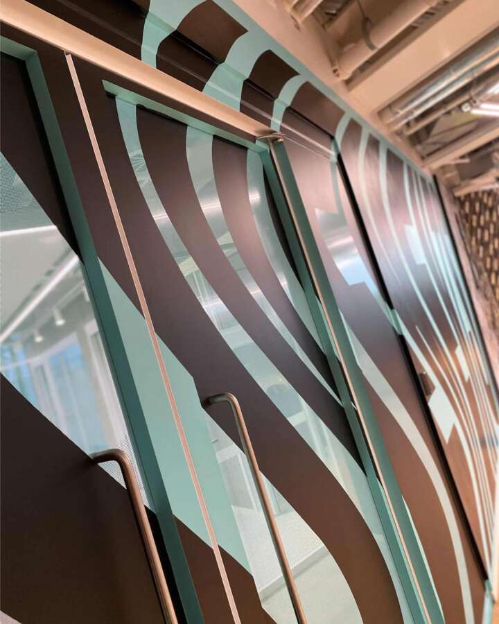 Lakwena mural artwork integrated across glass partitions inside Nike headquarters