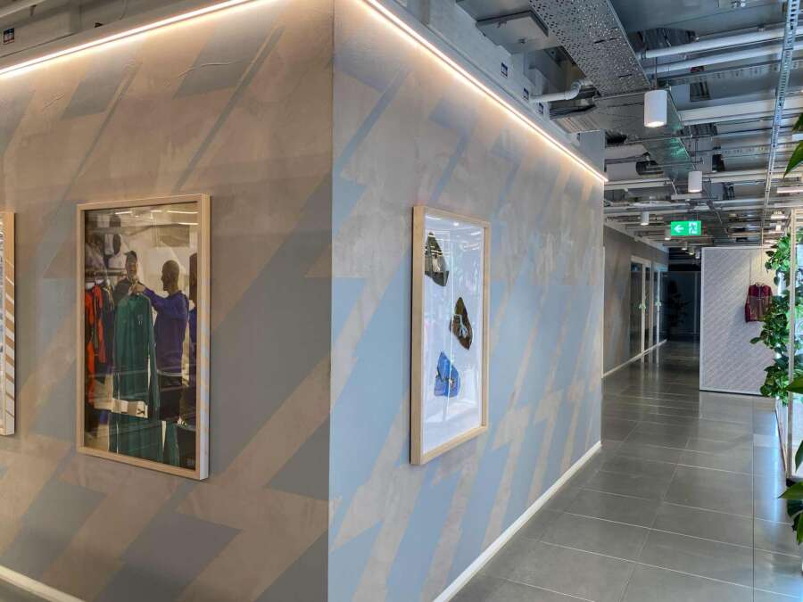 Long run of hand painted chevron graphics installed across textured concrete showroom walls