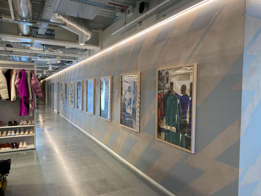 Hand painted chevron stripes forming a backdrop for framed Nike campaign images inside the showroom space