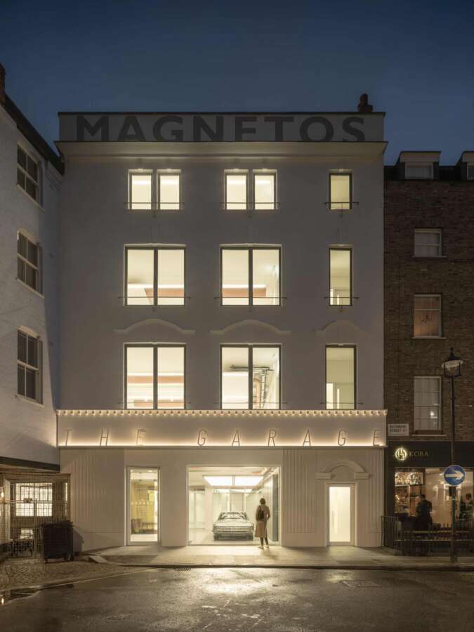 Restored Magnetos rooftop signage on Rathbone Street Garage building illuminated at night in Fitzrovia London