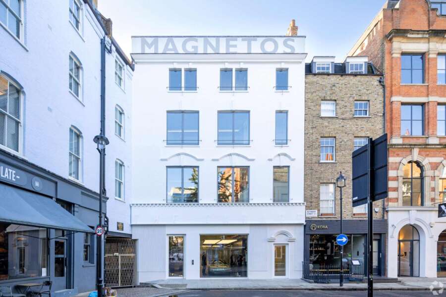 Hand painted Magnetos lettering recreated on rooftop parapet of restored garage building in Fitzrovia London